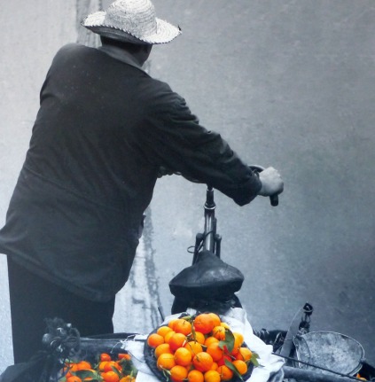 Photo of man on bike with oranges