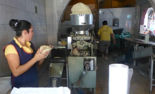 The tortilla machine. The glop at the top is simply ground corn and water.  Tortillas come out the other end. 
